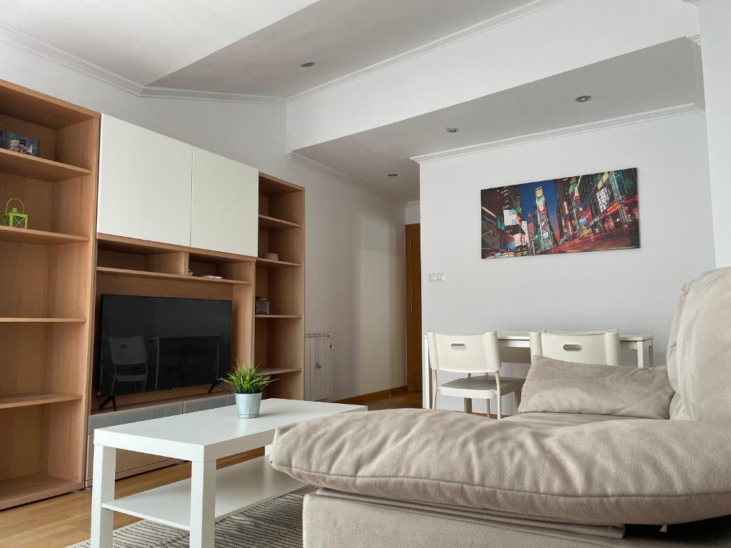 una sala de estar con un sofá y una mesa en Ático, en A Guarda