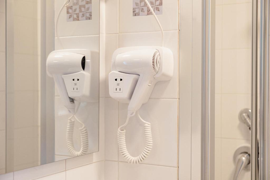 ロゼート・デッリ・アブルッツィにあるHotel BluMarineのバスルーム(壁に白いヘアドライヤー2台付)