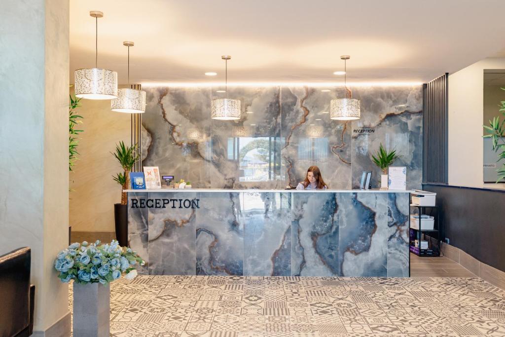 ロゼート・デッリ・アブルッツィにあるHotel BluMarineのロビーのフロントデスクに座る女性