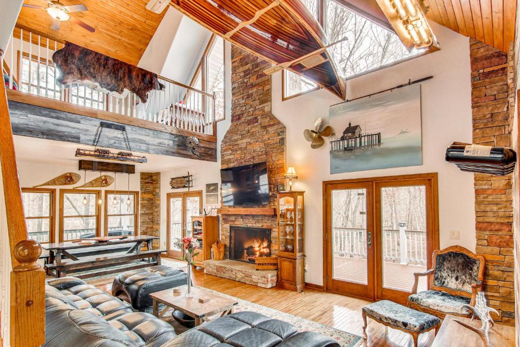 a living room with a couch and a fireplace at Riverfront Lake Lure Lodge with Deck on 13 Acres in Lake Lure