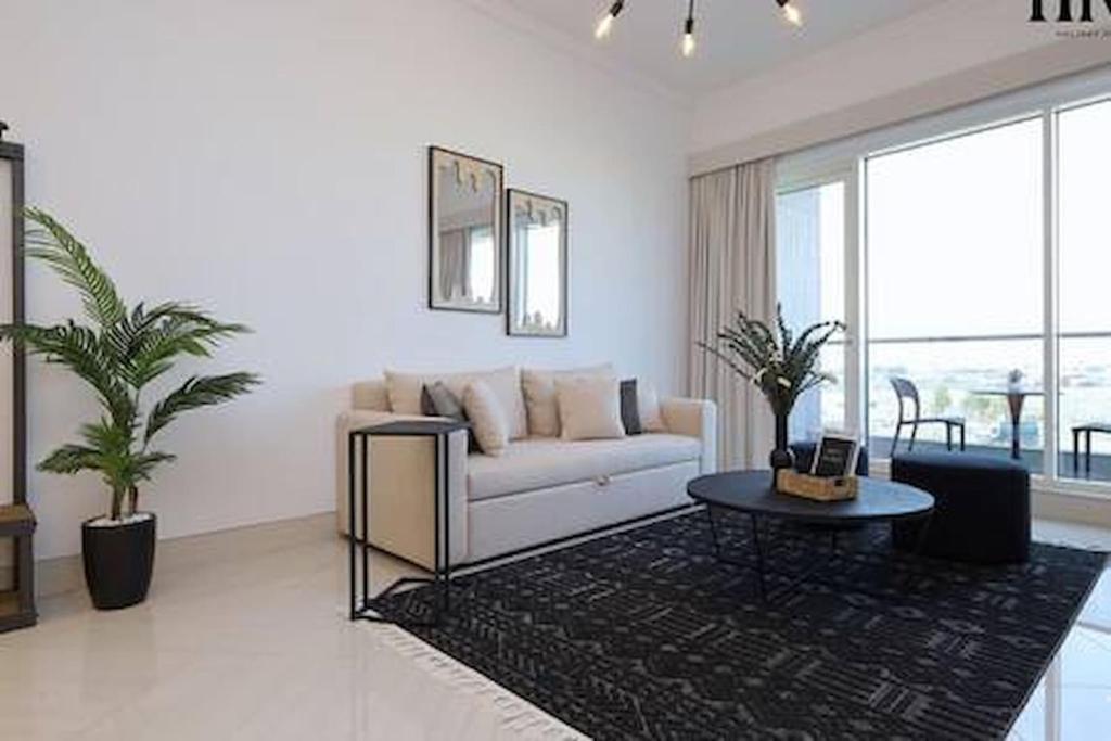 a living room with a white couch and a table at Gorgeous 2 Bed Apt in Al Warqa in Dubai