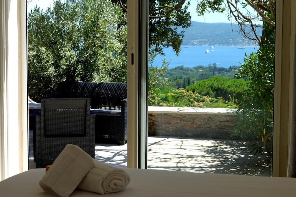 une porte donnant sur un patio avec vue sur l'eau dans l'établissement Villa piscine vue sur le golfe de Saint-Tropez, à Grimaud