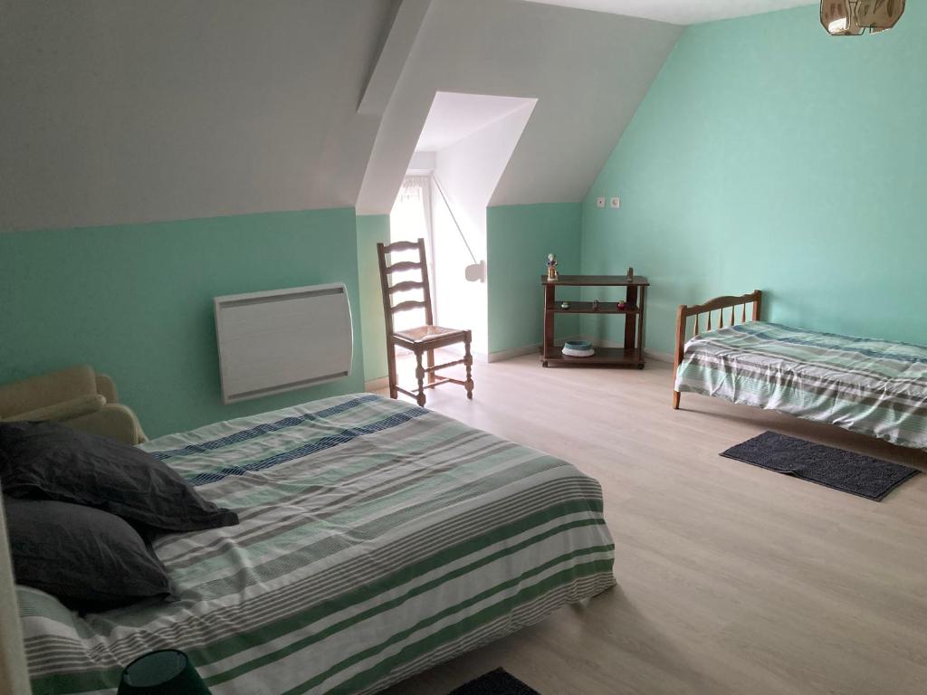 - une chambre avec 2 lits et 2 chaises dans l'établissement AU COEUR DE LA BRETAGNE ,Chez Colette et Gerard, à Bazouges-la-Pérouse