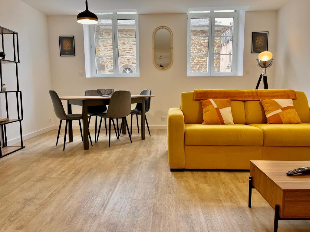 un salon avec un canapé jaune et une table dans l'établissement T2 1er LE VICTOR HUGO, à Cancale