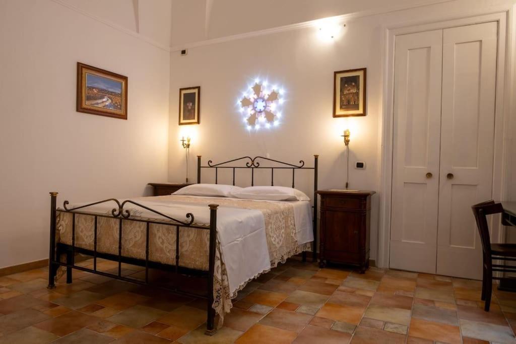 a bedroom with a bed and a door with a clock on the wall at Il geco d'oro elegance in Lecce
