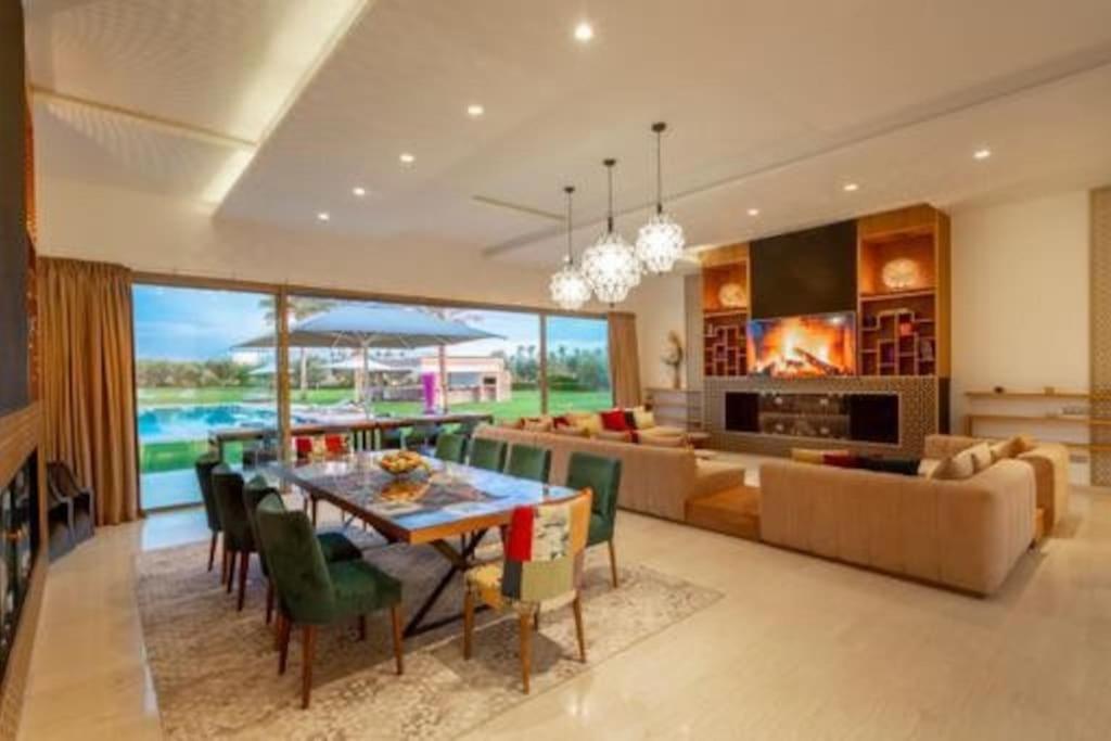a dining room and living room with a table and chairs at Villa des stars in Marrakesh
