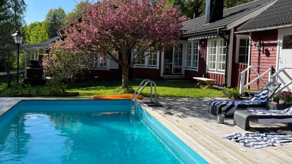 a swimming pool in front of a house at Charming property with private pool in Märsta