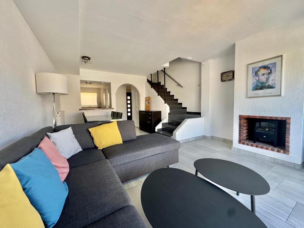 a living room with a couch and a fireplace at Maison Empuriabrava proche canaux et Plage in Empuriabrava