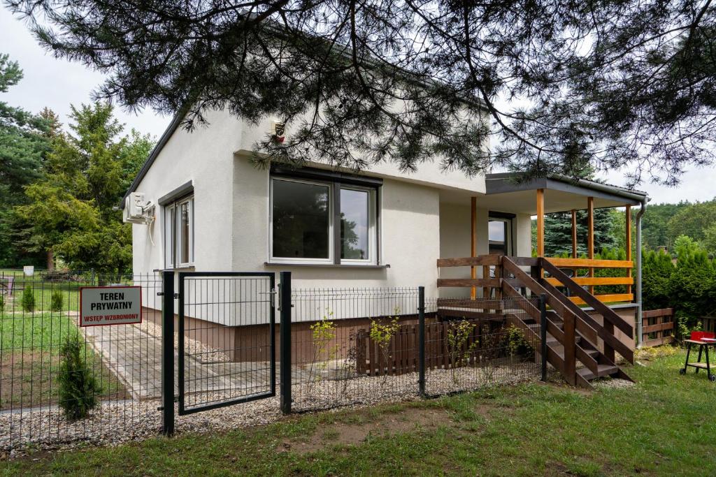 a small house with a fence in front of it at Domek Letniskowy 4E nad jeziorem nyskim in Skorochow