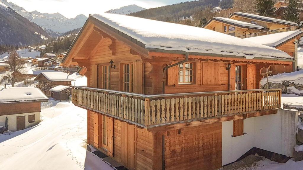 une maison en bois avec de la neige sur le toit dans l'établissement Chalet Bellevue, à La Tzoumaz