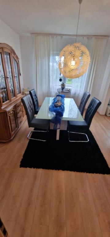 a dining room with a table and chairs and a chandelier at Stadtrand Haushälfte in Wilhelmshaven