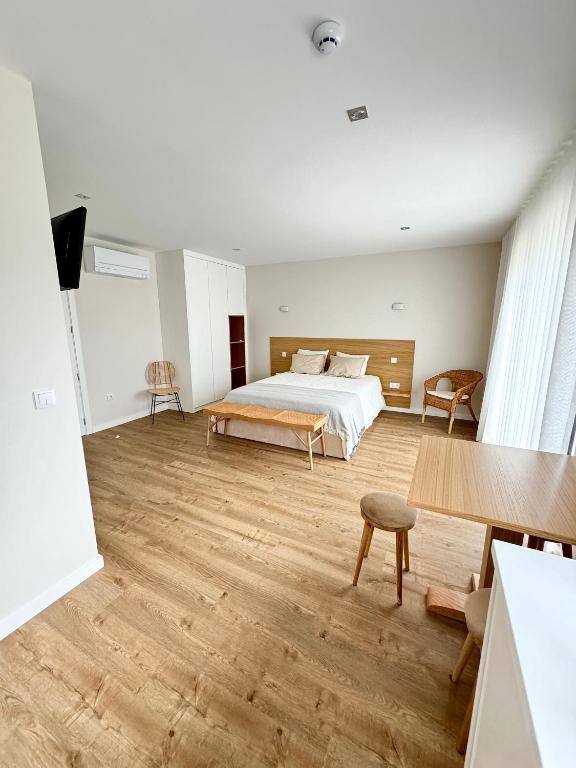 a bedroom with a bed and a wooden floor at Refúgio Verde Douro in Marco de Canaveses