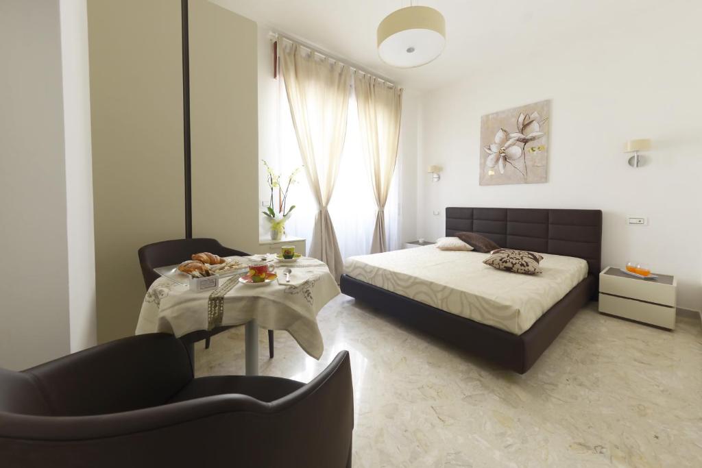 1 dormitorio con 1 cama, mesa y sillas en B&B La Vie en Rose, en Salerno