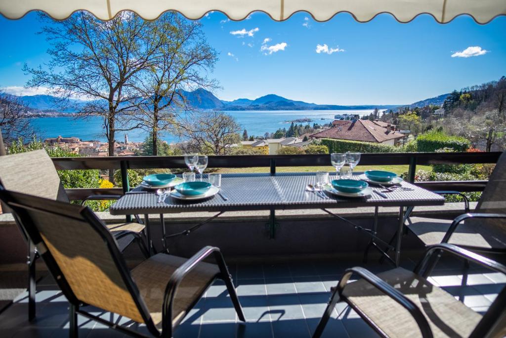 a table on the balcony with a view of the water at Pineta Tre Isole in Baveno