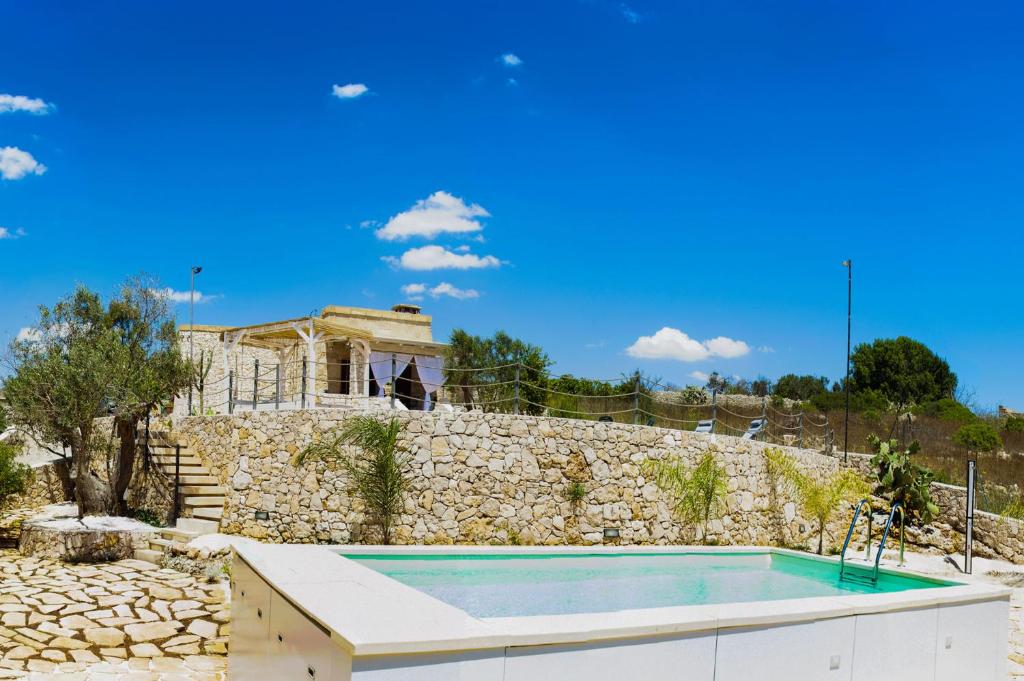 Cette villa dispose d'une piscine et d'un mur en pierre. dans l'établissement Villa Luce, à Leuca