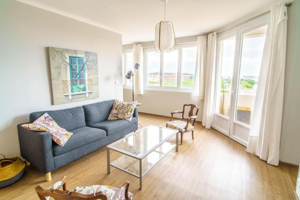 un salon avec un canapé bleu et une table en verre dans l'établissement Appartement avec vue hypercentre, à Toulouse