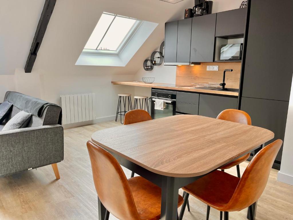 une cuisine et une salle à manger avec une table et des chaises dans l'établissement LE VICTOR HUGO, à Cancale