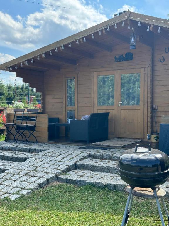 a barbecue grill in front of a house at Domek przy Róży in Ostromice