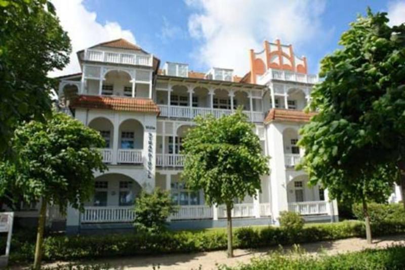 ビンツにあるHaus & Villa Strandidyll by Rujanaの目の前に木々が植えられた白い大きな建物