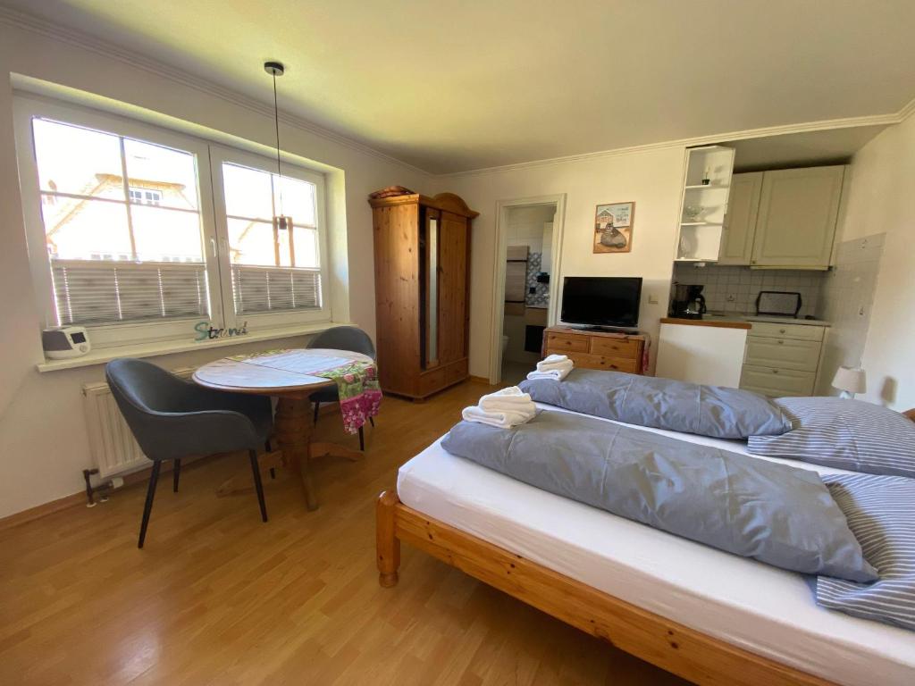 a bedroom with a bed and a table and a kitchen at Sylvie-Steinhardt-Wohnung-4 in List