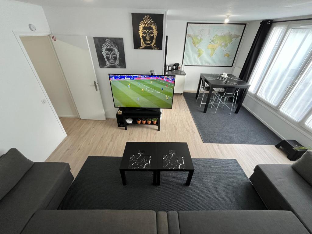 un salon avec un canapé et une télévision dans l'établissement Decathlon Arena Stade Pierre Mauroy à 5mn à Pieds, à Villeneuve d'Ascq