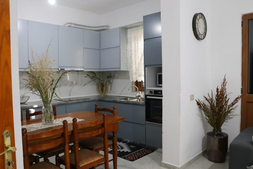 a kitchen with blue cabinets and a wooden table at Green garden house in Shkodër