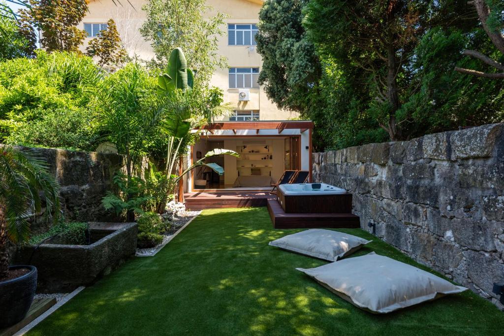 a garden with two pillows on the grass at BmyGuest - The Marquis Luxury Garden Apartment in Porto