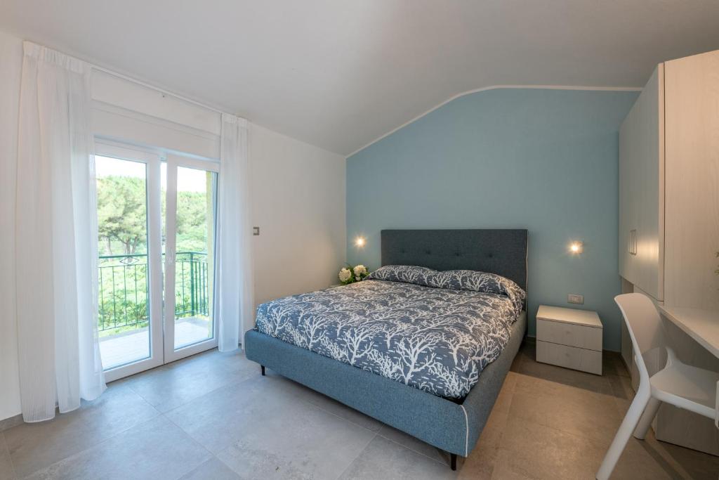 a bedroom with a bed and a large window at Costabella Rooms in Deiva Marina