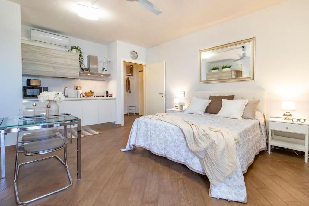 Un dormitorio con una cama y una mesa y una cocina. en Pisa AirPort-Train Station AC Free Parking, en Pisa