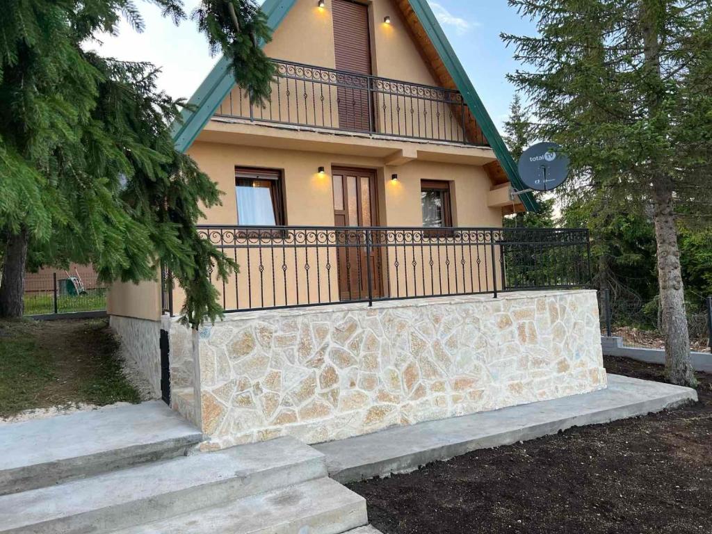 a house with a stone wall in front of it at Žabljak- FamilyOasis in Žabljak