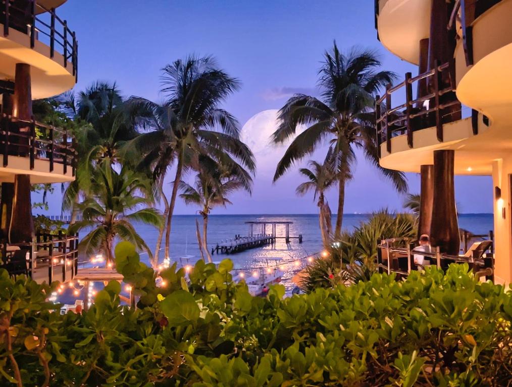 a view of a resort with palm trees and the ocean at El Taj Oceanfront and Beachside Condo Hotel in Playa del Carmen