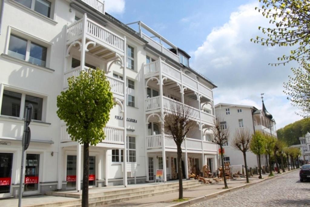 ein weißes Gebäude mit Balkon auf einer Straße in der Unterkunft Villa Allegra by Rujana in Binz