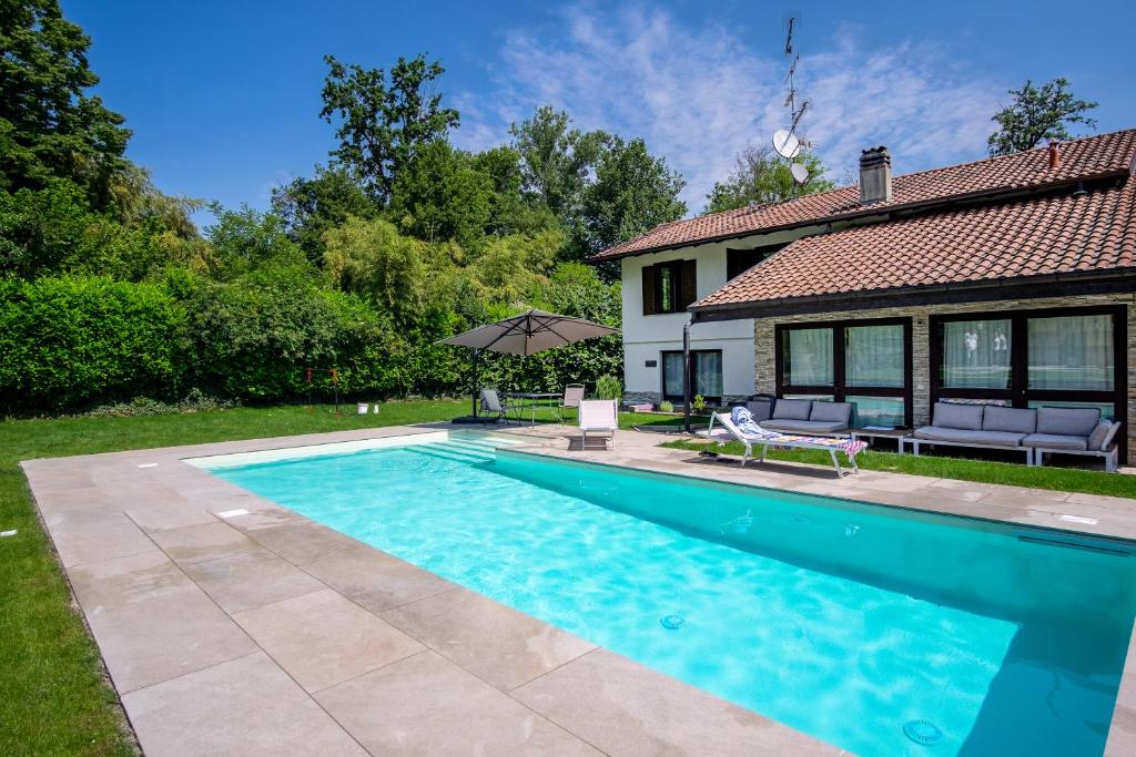ein Swimmingpool vor einem Haus in der Unterkunft VILLA NOVELLI con Piscina e ampio Giardino in Castelletto sopra Ticino