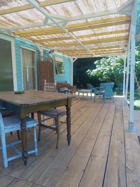 une terrasse en bois avec une table et des chaises en bois dans l'établissement Mobile home style créole, à Graveson