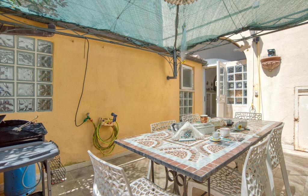 kuchnia ze stołem, krzesłami i zlewem w obiekcie 3 Bedroom Lovely Apartment In Canino w mieście Canino