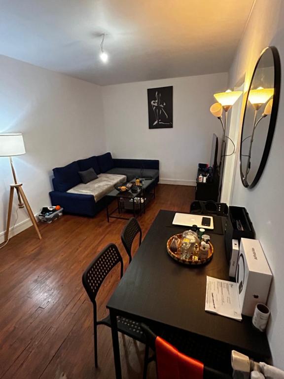 un salon avec une table et un canapé bleu dans l'établissement Appartement meublé très bien situé, à Boulogne-Billancourt