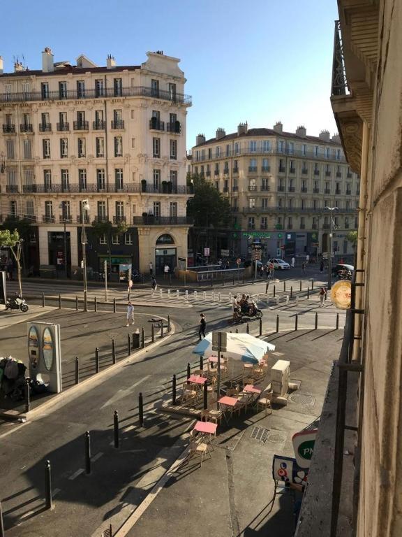 une rue de la ville avec des bâtiments, des tables et des bâtiments dans l'établissement Appartement 6 personnes place de la joliette, à Marseille