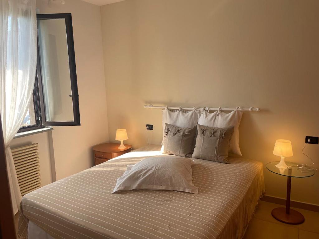 Un dormitorio con una cama con dos lámparas y un espejo. en A casa di Ale, en Lanciano