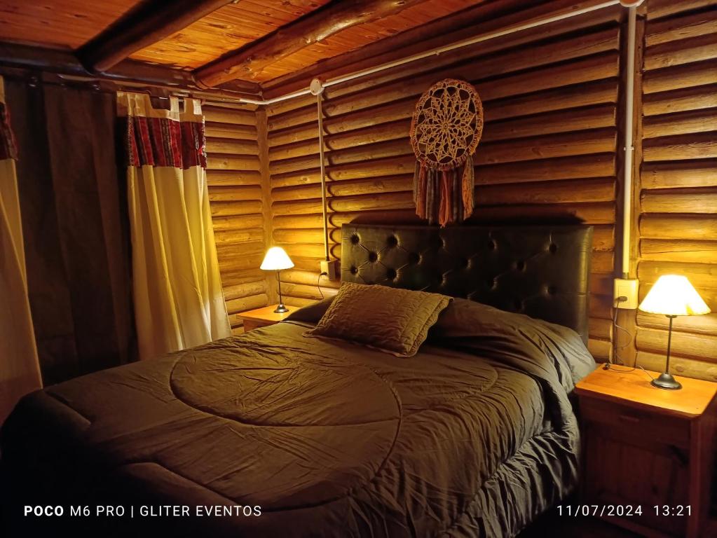 a bedroom with a bed in a room with wooden walls at Amphu mariposa in La Falda