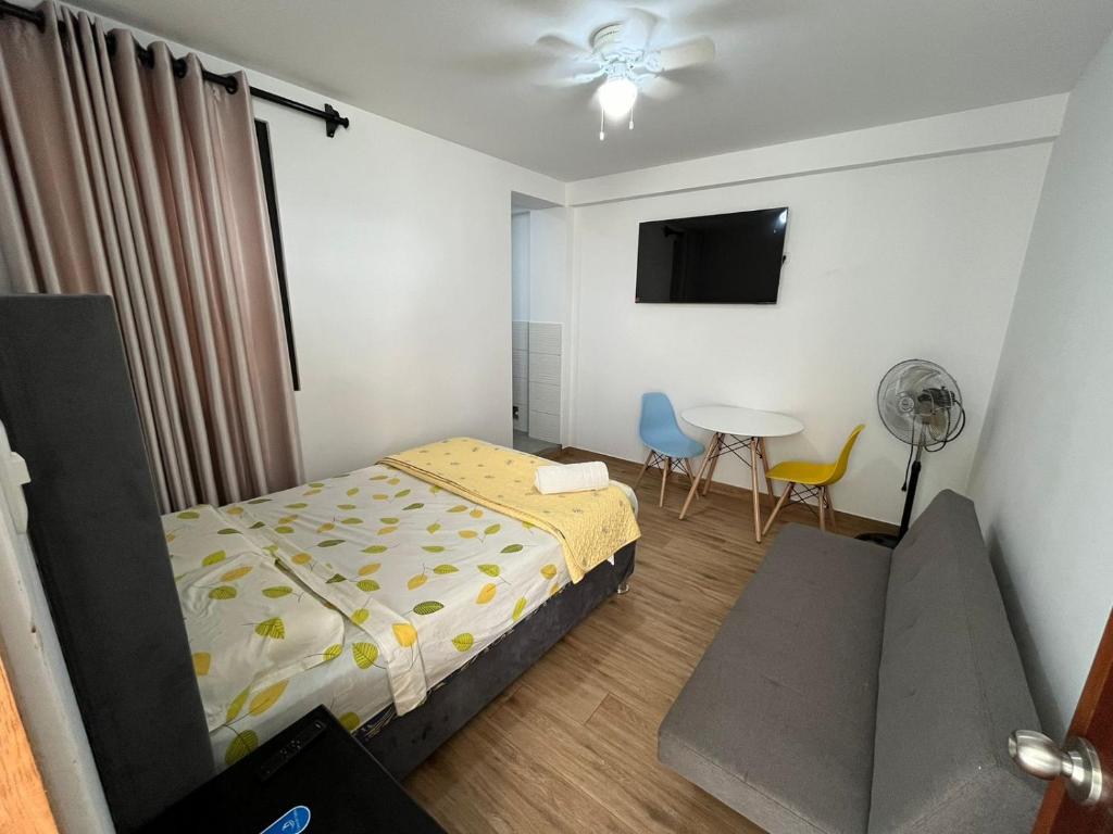 Schlafzimmer mit einem Bett, einem Tisch und einem Ventilator in der Unterkunft Casa de Anita 03 in Malabrigo