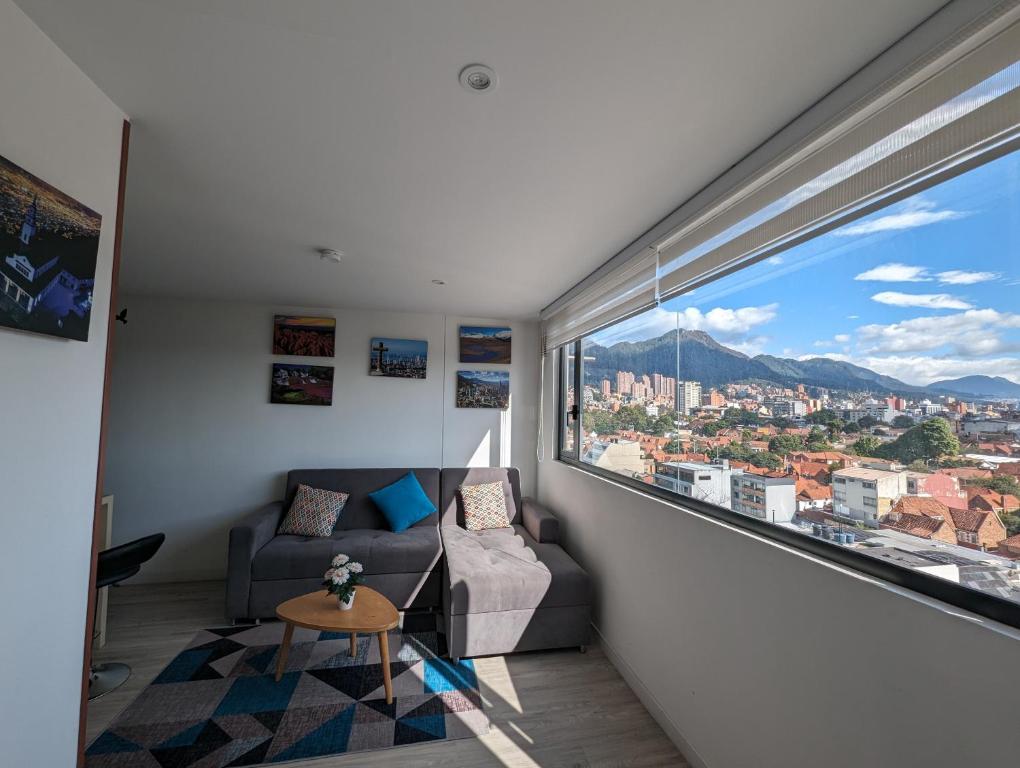 a living room with a couch and a large window at Nice flat in financial heart of Bogotá in Bogotá