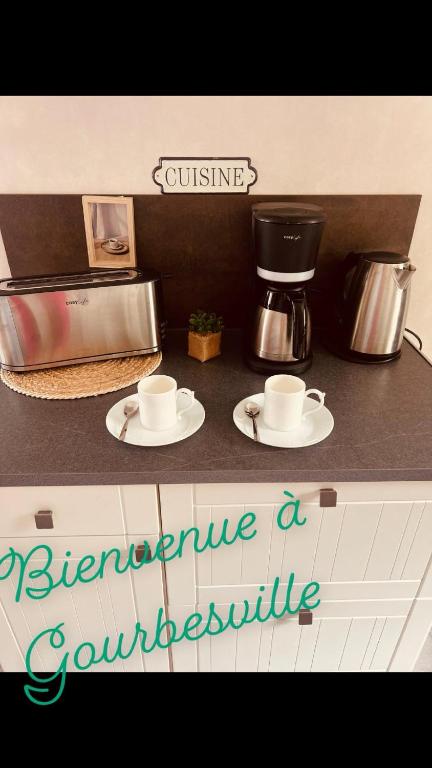 - un comptoir avec 2 tasses et une cafetière dans l'établissement Maison vacance proche ste mère église, à Picauville