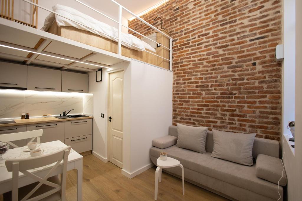 a living room with a couch and a brick wall at Banffy's little house in Cluj-Napoca