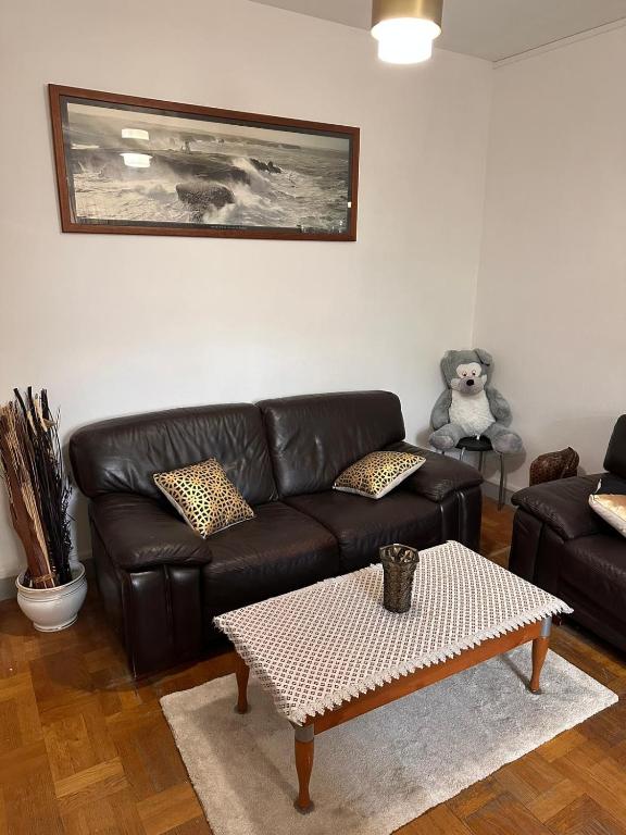 - un salon avec un canapé en cuir et une table basse dans l'établissement Appartement à Boulogne Billancourt proche de Paris, à Boulogne-Billancourt
