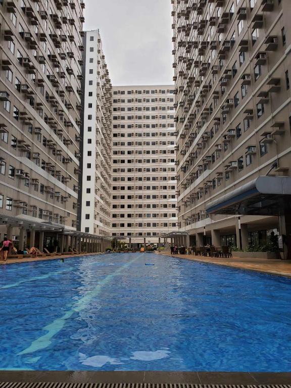 a swimming pool in front of two tall buildings at Cavite RAF Condotel in Dasmariñas