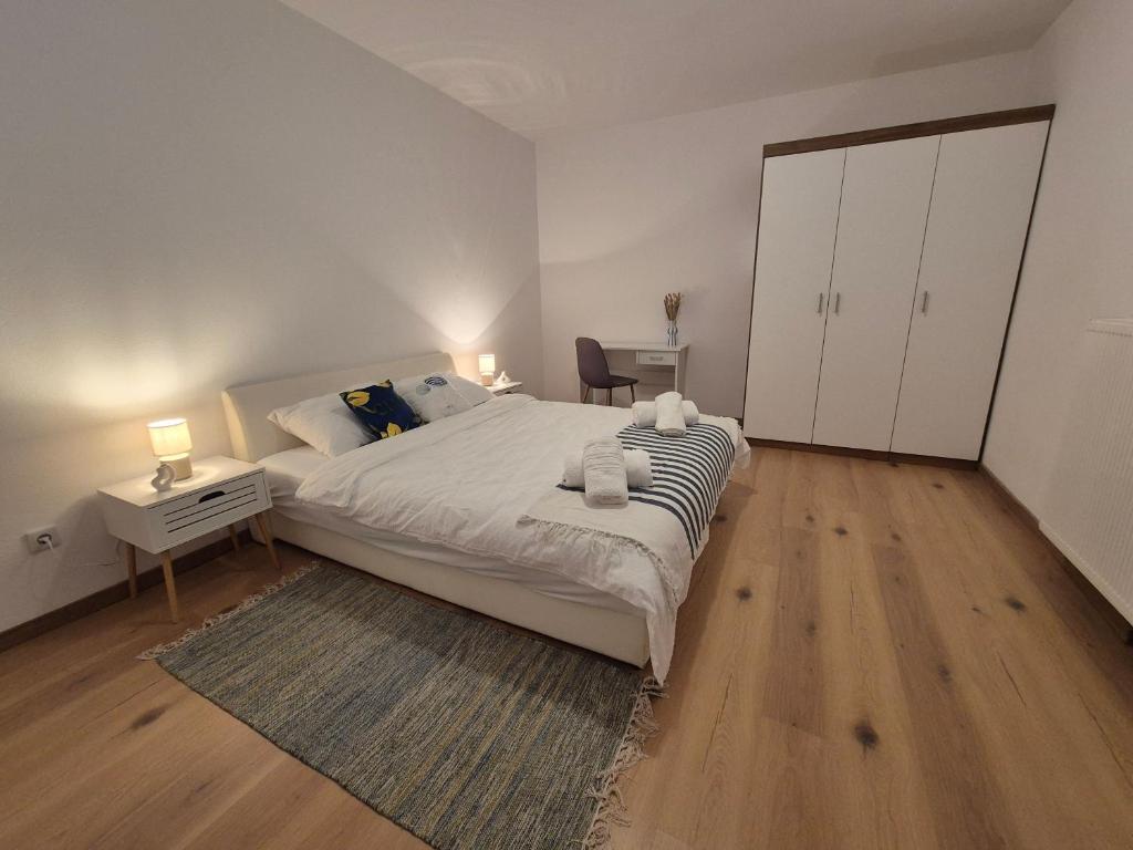 瓦比尼科Apartman Uptown的卧室里有一张白色的大床和一张书桌