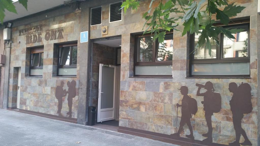 un edificio con un mural de personas a su lado en Albergue Bide-Ona, en Portugalete