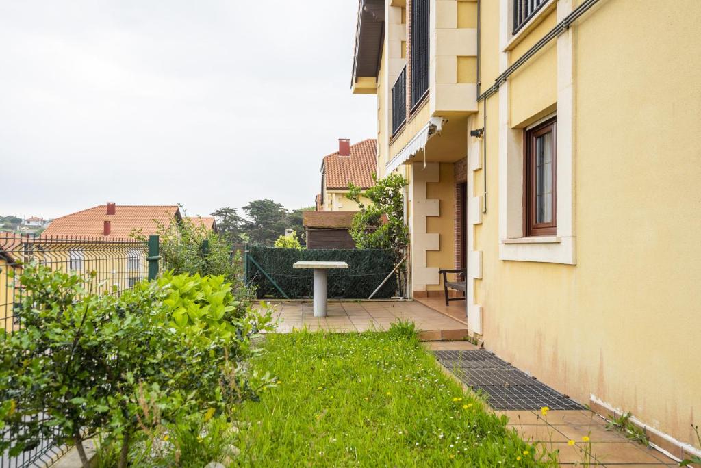 un giardino con tavolo al centro di un edificio di Apartamento Ruiloba-Comillas a Casasola