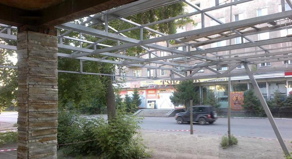 awning over a parking lot next to a building at Polet Hotel in Omsk