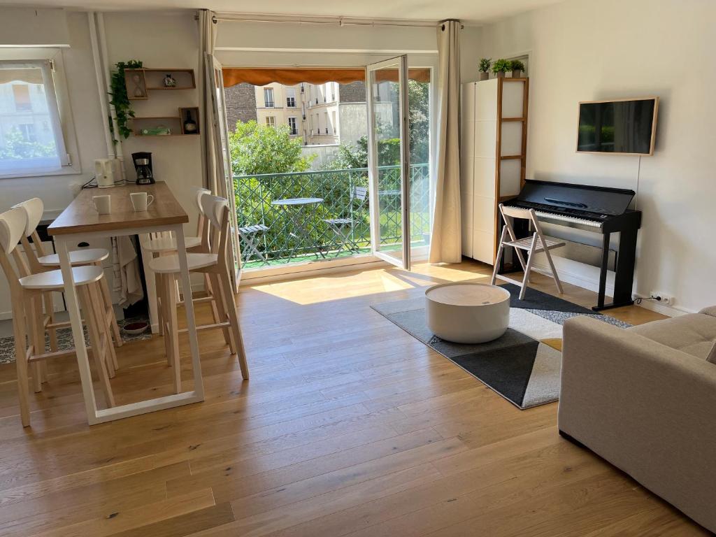 un salon avec une table et un piano dans l'établissement Superbe appartement avec belle vue jardin, à Paris